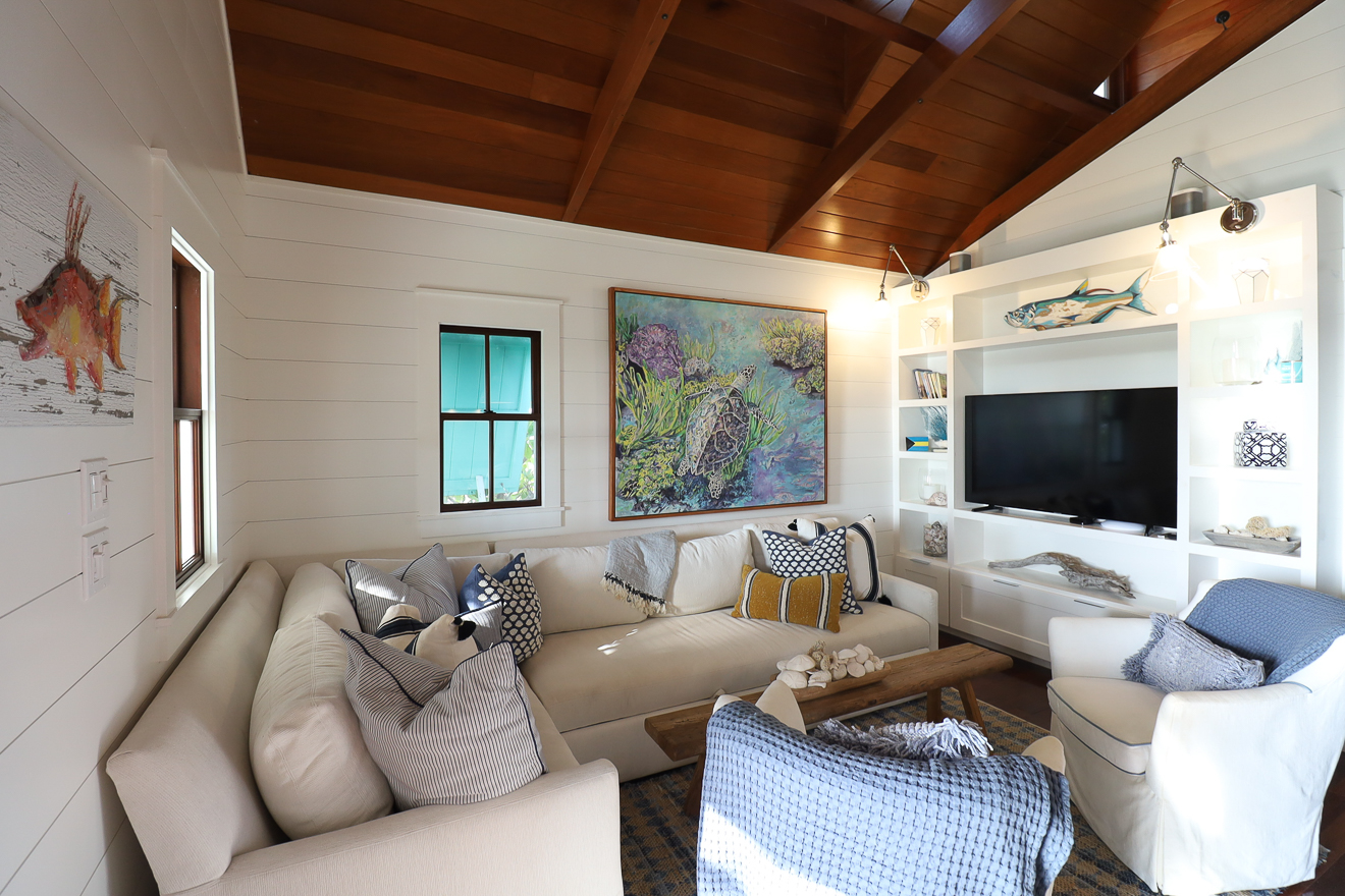 Living room with built-in TV unit, coastal décor, and open-plan layout