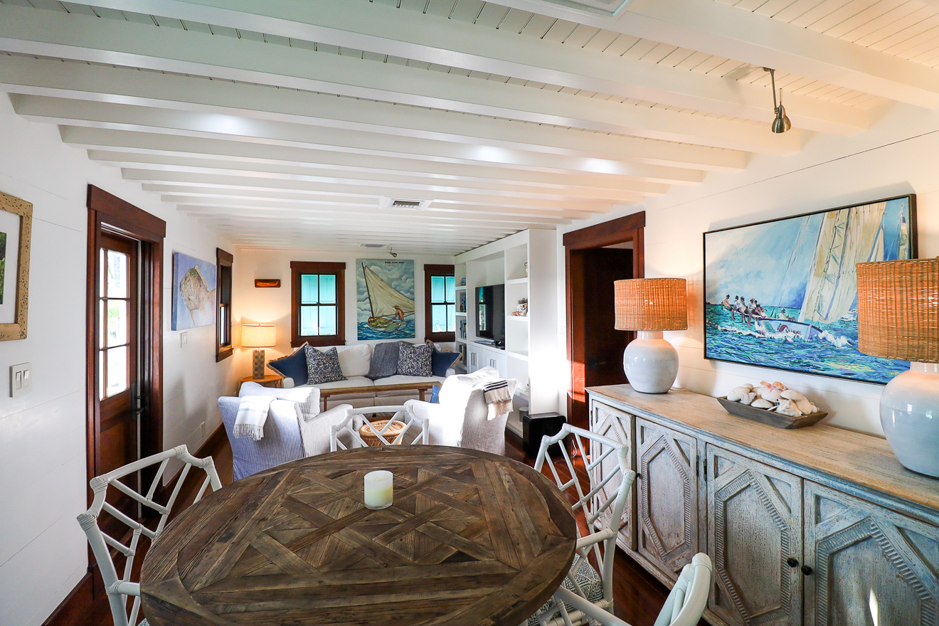 Cottage One dining and living open plan with round table and nautical décor