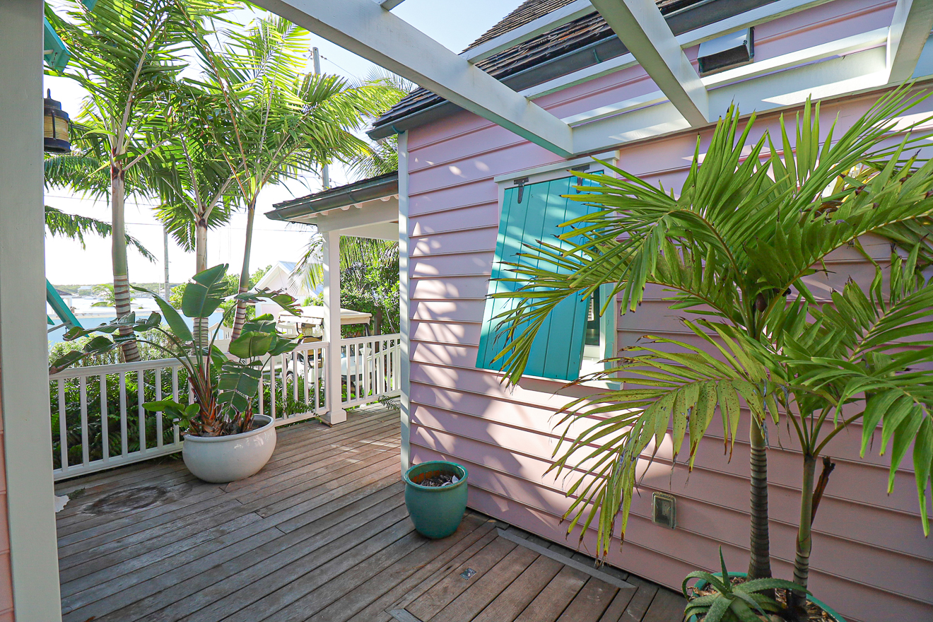 Deck and veranda of Cottage Two with tropical palms and ocean glimpse