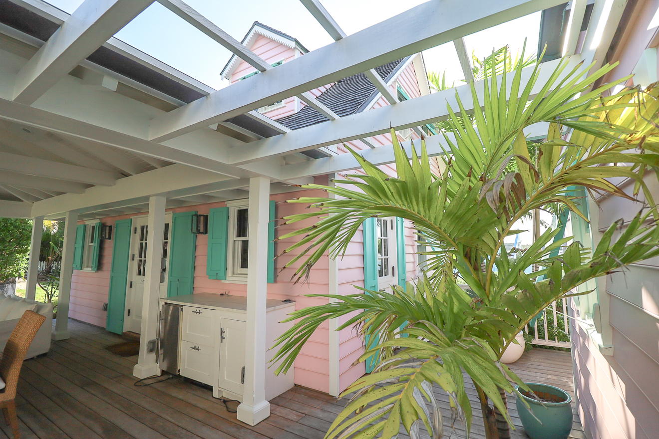 Covered veranda with polycarbonate pergola roof, looking toward cottage facade